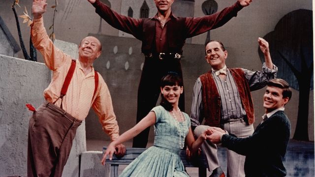 Four men and one woman dance on a stage.