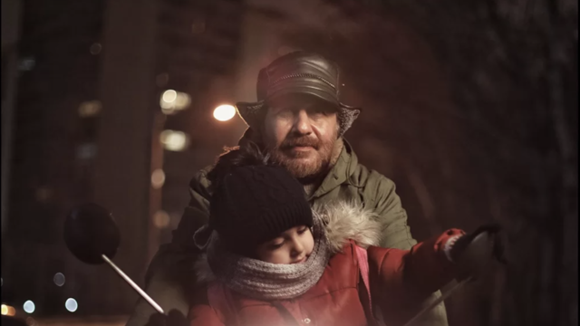 A man holds his child in a warm puffy jacket.