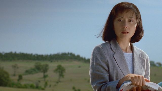 Woman holding books looks past camera