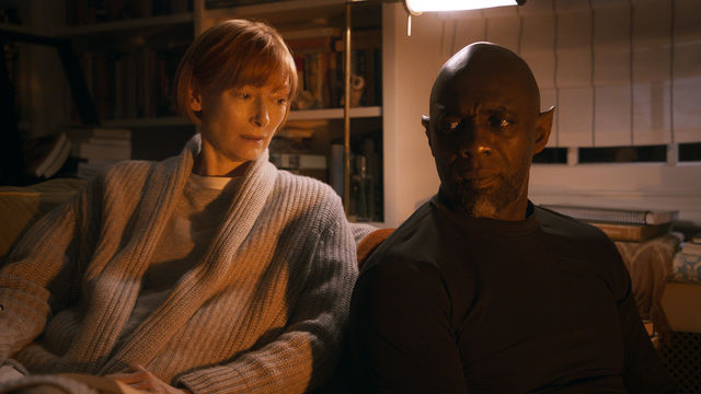 Still from the film "Three Thousand Years of Longing" (2022), showing Tilda Swinton sitting next to Idris Elba on a couch