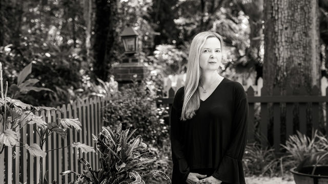 Ange Mlinko standing in a garden