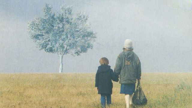 a woman and child hold hands in the open field