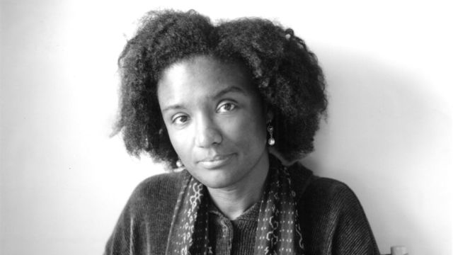 Harryette Mullen, holding an open book on her lap