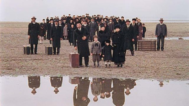 People stand on edge of water dressed formally