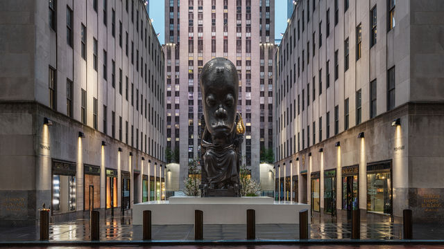 A large sculpture of a seated figure installed outside Rockefeller Center in New York City