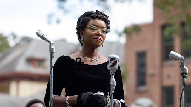 Still from the film "Till" (2022), depicting the character Mamie Till speaking in front of an array of microphones