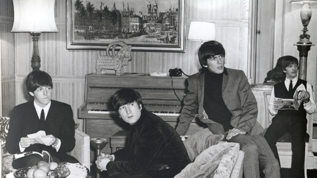 The beatles sit around the studio, shot in black and white