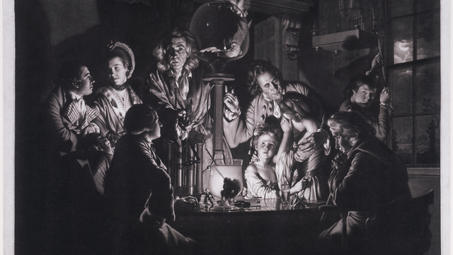 Scene of people surrounding an old time air pump