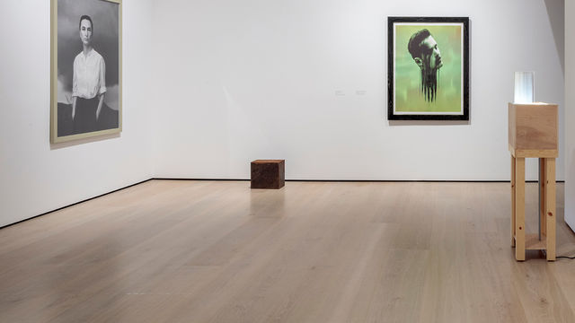 Installation view of four works, including a cube on the floor