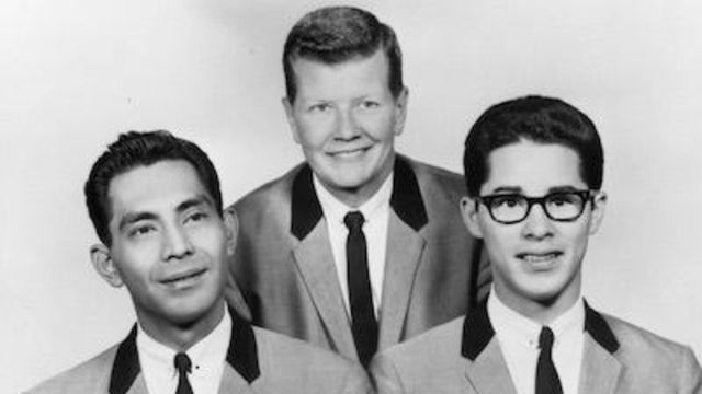 Black and white image of three men in matching suits