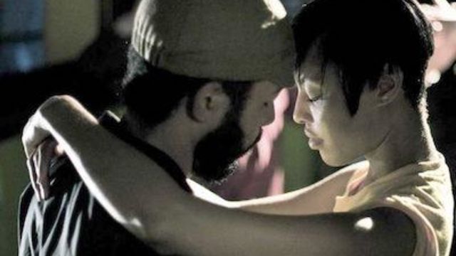 A man and a woman slow dance, their foreheads pressed together