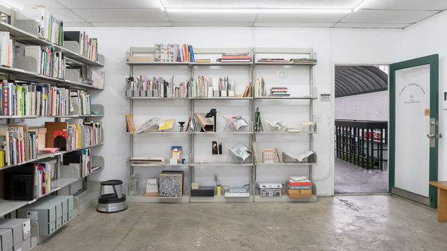 Photo of shelves filled with books, objects, and ephemera
