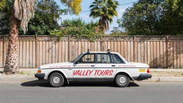 Photo of a tan car with "VALLEY TOURS" painted on the doors