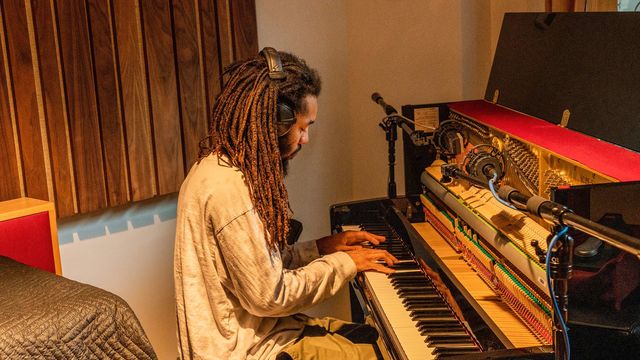 Musician Jamael Dean sits at a piano