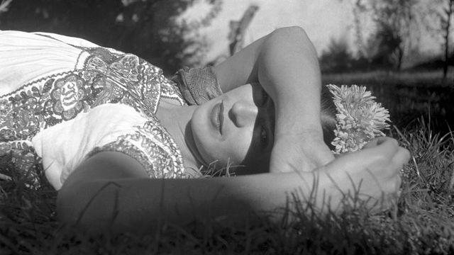 Artist Frida Kahlo laying in the grass