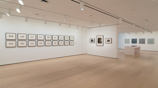installation image of works on paper framed on walls
