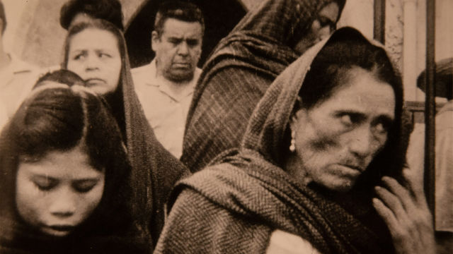 Black and white still of people outside of a church