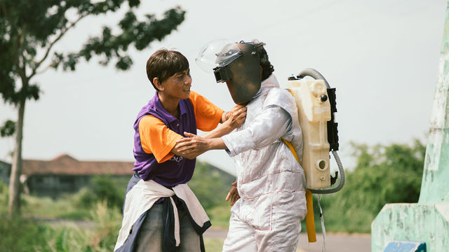 Film still featuring two figures, one wearing a homemade astronaut costume