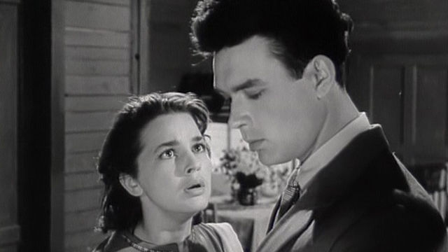 a young lady looking at another young man in suit