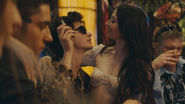 a young man holding another young woman in a bar