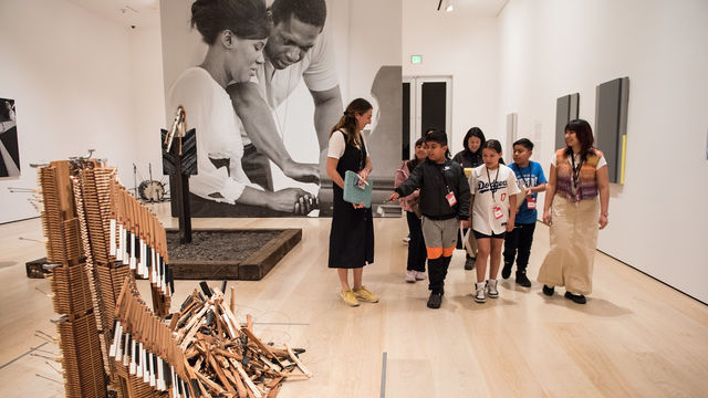 Museum educators lead a group of children through an art exhibition