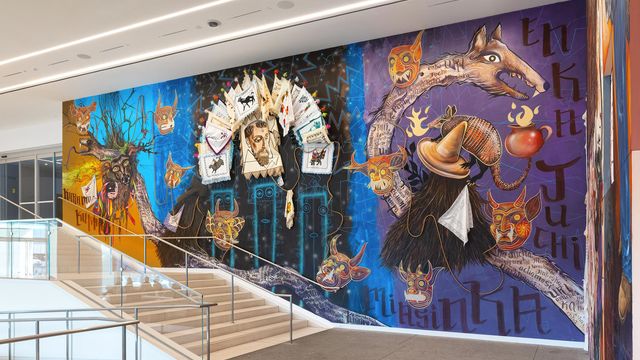 View of a museum lobby, walls covered in colorful murals