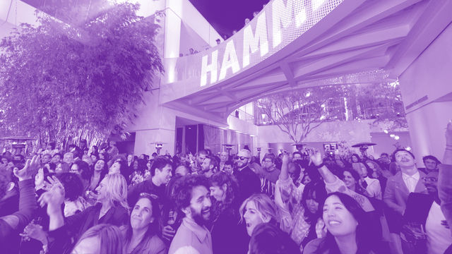 A crowded museum courtyard full of smiling, dancing visitors