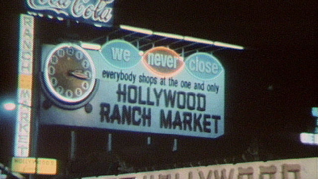 Large billboard sign with a clock reading: We Never Close - Hollywood Ranch Market"