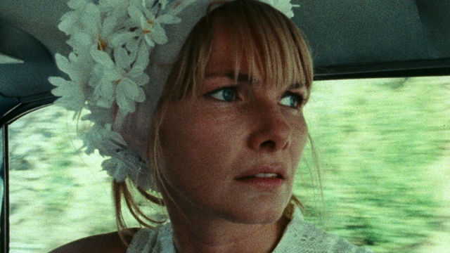 A woman wearing a flowers in her hair seen in close up