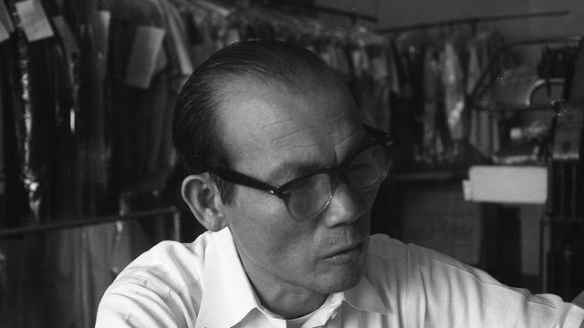Black and white still of a man in a dry cleaning business