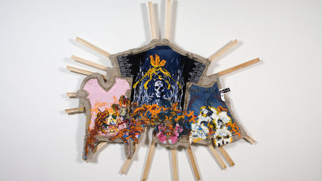 Multicolored material hanging on approx. 16 wood bars