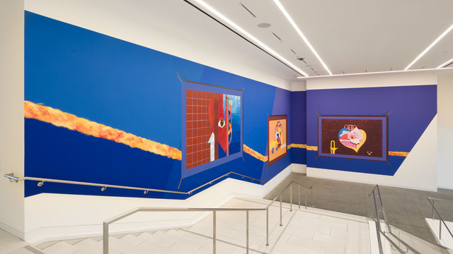 Mural on a bright blue background, installed along a large museum stairway