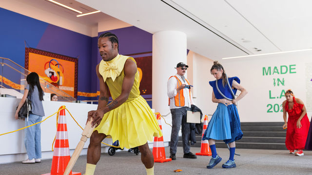Brightly dressed dancers in the lobby of the Hammer Museum