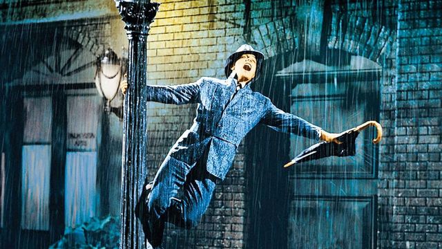Gene Kelly spins around a lamppost in the rain