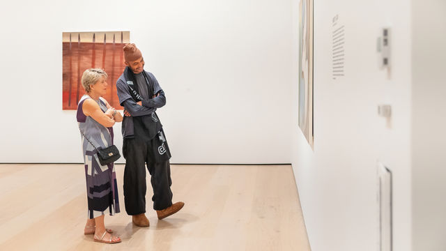 Two museumgoers look at a work of art