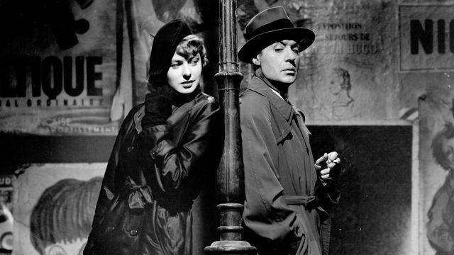 Ingrid Bergman and Charles Boyer stand back to back, a lamppost between them