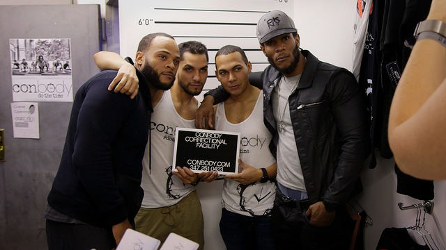 Four men pose with a sign reading "Conbody Correctional Facility"