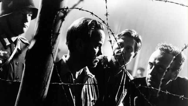 Prisoners behind a barbed wire fence