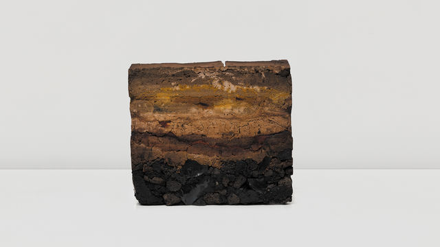 Striated block of compacted natural materials