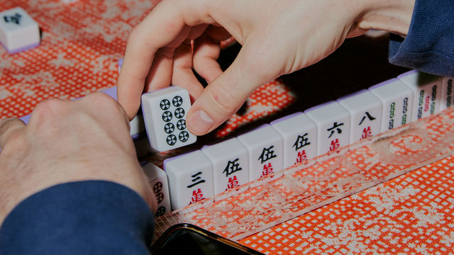 Close up of hands playing mahjong