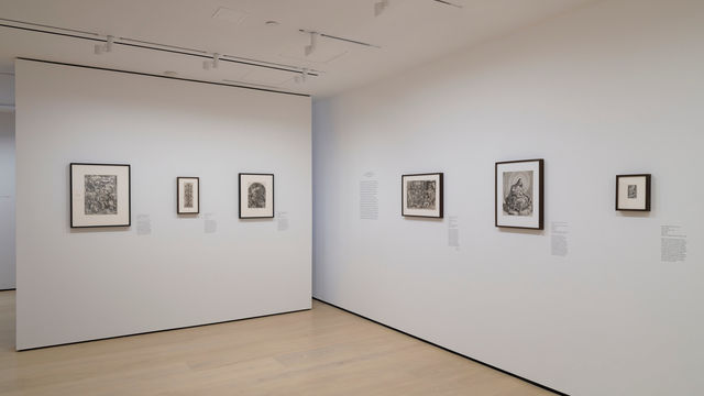 Gallery with framed works on paper mounted on the wall