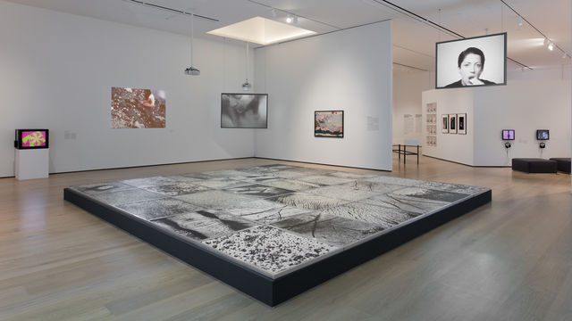 In the Body as Landscape section of the exhibition, the floor is dominated by Epidermic Scapes (1977/1982), an installation by Vera Chaves Barcellos composed of large scale photographs showing details of the body. Projected on the left wall is Ana Mendiata’s Corazón de Roca con Sangre (Rock Heart with Blood) (1975), in which she takes a heart-shaped rock and covers it in blood, laying it in one of her “Siluetas” sculptures before placing her naked body over it.