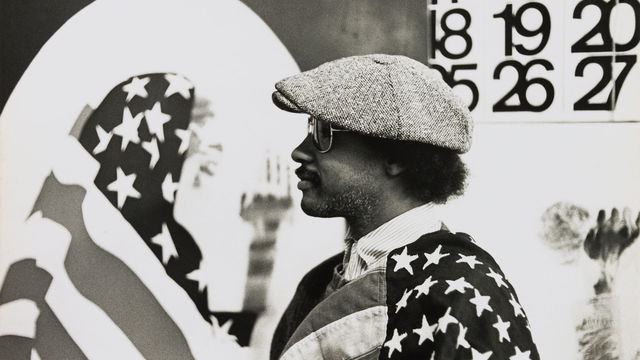 David Hammons in his Los Angeles studio, 1970. "Pray for America," 1969, is shown at left and a portion of "Wine Leading the Wine," c. 1969, is visible at right