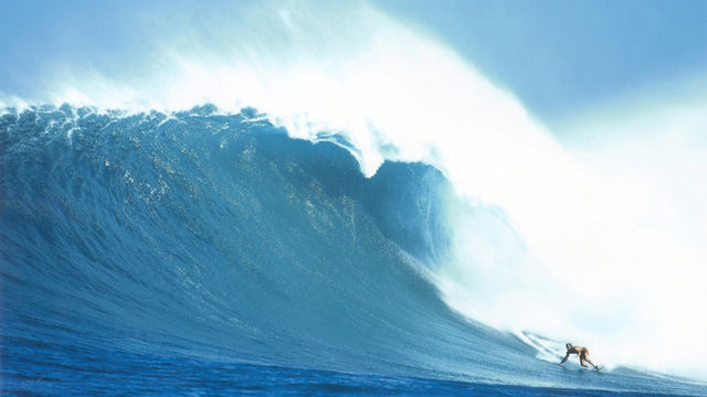 Surfer riding large wave