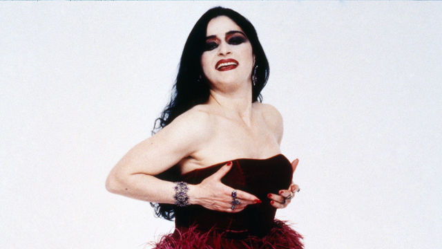 Astrid Hadad poses in a strapless dress with a skirt of red and black eyes.