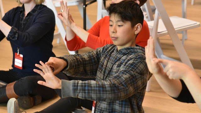 Children seated at the Hammer, practicing hand movements.