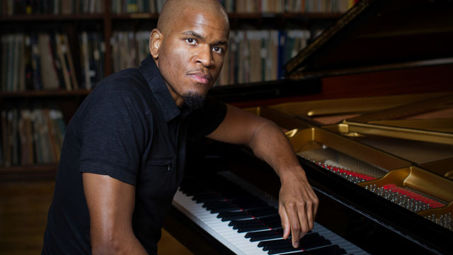 Joshua White sitting at a piano