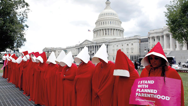 Women dressed as handmaids from the novel, film, and television series "The Handmaid's Tale" demonstrate against cuts for Planned Parenthood in the Republican Senate healthcare bill at the U.S. Capitol in Washington, U.S., June 27, 2017. REUTERS/Aaron P. Bernstein.