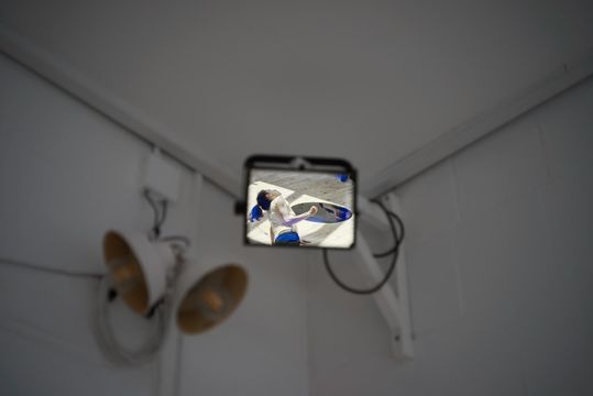 The image of a person's upper body on a digital display, with a blurry background.