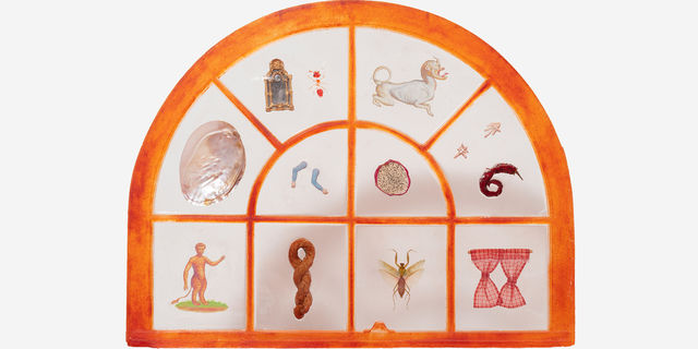 A hanging lightcatcher, framed in orange, with small objects or icons in each window pane
